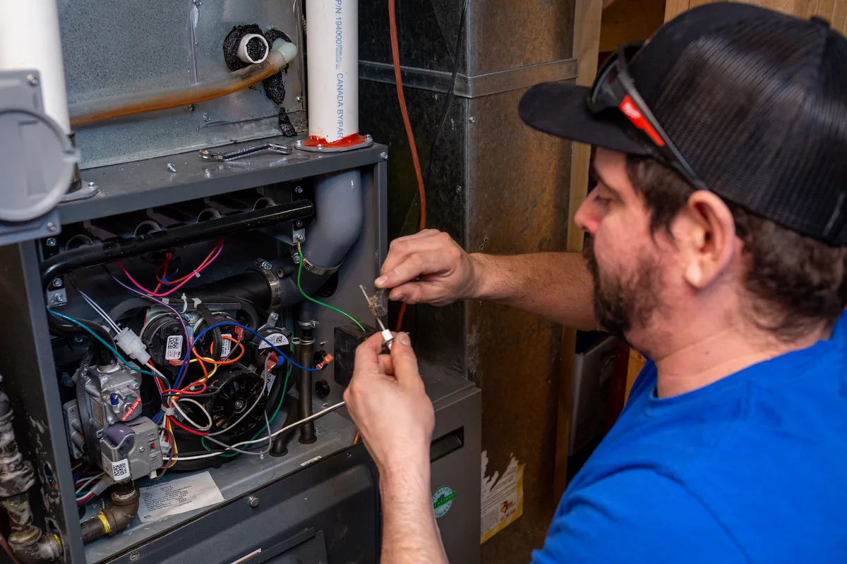 Vero Mechanical technician maintaining a furnace